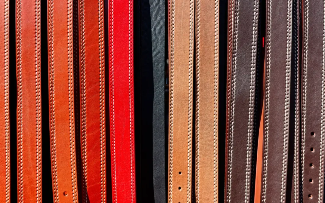 Leather belts displayed vertically in a range of colors