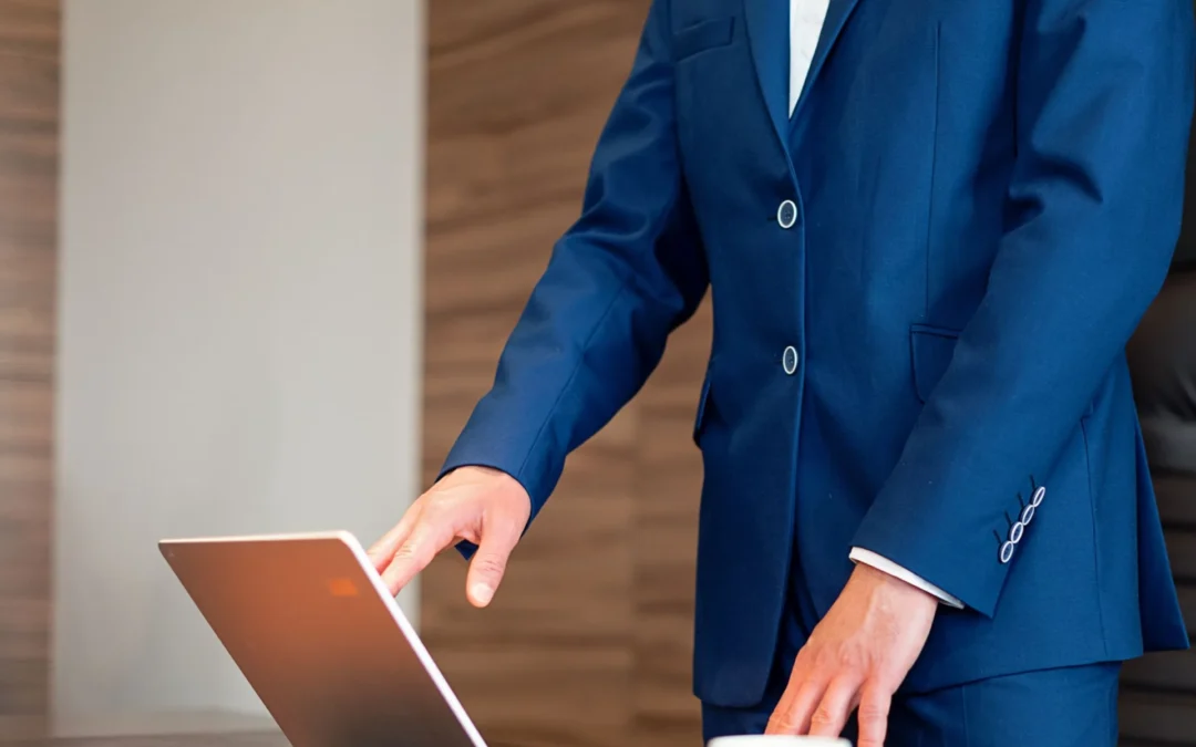 Business professional in a suit using a laptop in an office